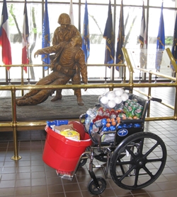 wheelchair with luncheon stuff in front of the Corpsmen statue in the lobby